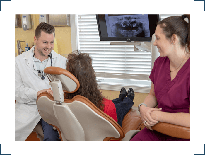 Dr McCabe talking to patient about full in-house dental implant care Select Dental
